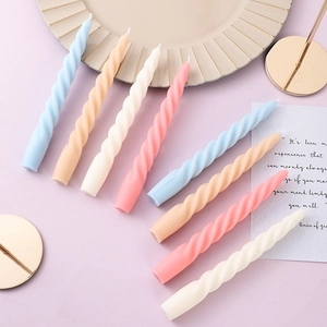 Eight spiral colorful taper candles in pastel shades on a gold tray for home decor