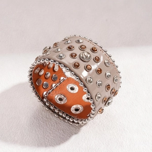 Détail d'un bracelet punk large en cuir avec rivets et pierres précieuses