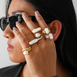 Detail of baroque pearl double-layer rings with zircons on model's fingers