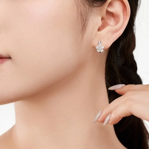 Detail of silver five-petal flower hoop earrings with pavé rhinestones on model