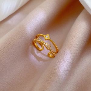 Detail view of gold bow knot double-layer ring with sparkling white cubic zirconia