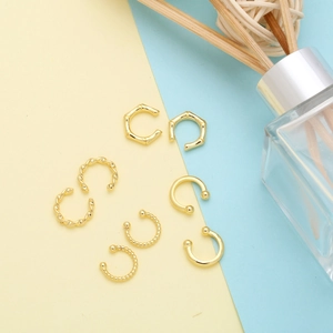 Set aus vier minimalistischen goldenen Ohrklemmen mit Bambus-, Seil- und Perlenstruktur
