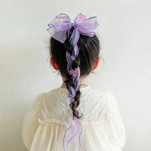 Detailed view of purple tulle bow hair clip and floral ribbon braided in girl's hair