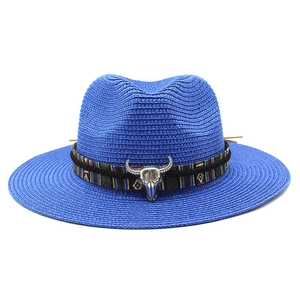 Dettaglio cappello in paglia blu con nastro etnico e teschio di toro in metallo