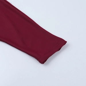 Detailed macro view of burgundy knit fabric sleeve cuff with professional stitching