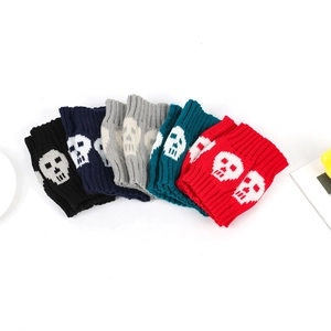 Close-up of five pairs of knit leg warmers with white skull patterns in various colors