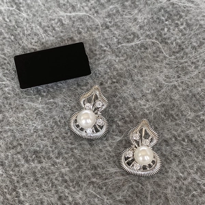 Elegant silver hollow gourd stud earrings with pearls and zircon on plush background