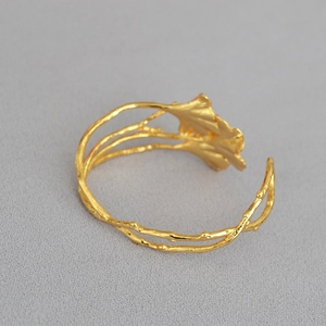Artistieke goudkleurige ginkgo blad open armband met vintage taktextuur en matte afwerking