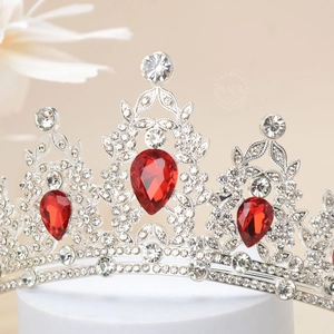 Macro shot of silver wedding crown with red teardrop stones and micro-paved rhinestones
