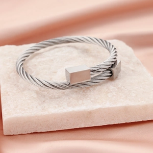 Silver twisted cable stainless steel bangle with rectangular ends on white stone