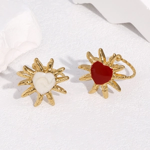 Detailed view of 18k gold plated sunburst rings with red and white heart centerpieces