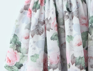 Nahaufnahme des rosa Rosen-Blumendrucks auf weichem Chiffon mit zarter Faltenstruktur