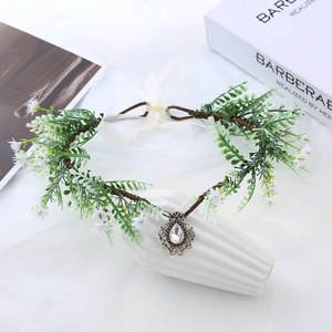 Macro detail of fairy flower crown featuring vintage silver pendant and silk ribbon