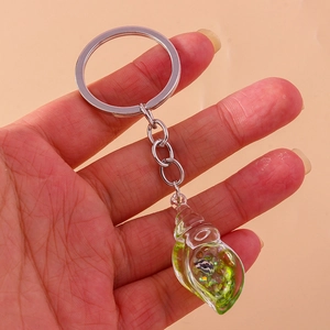 Detailed view of creative seashell keychain with green glitter and shell in liquid resin