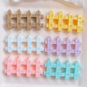 Close-up of colorful mini resin fences for DIY crafts in pink, blue, and yellow colors