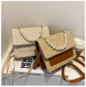 Minimalist straw crossbody bag with pearl handle and leather strap for women