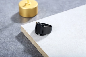 Detailopname van een brede ring met een grote zwarte edelsteen en matte zwarte afwerking