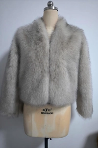 Détail d'un manteau gris en fausse fourrure montrant la texture épaisse et duveteuse