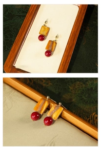 Dettaglio macro di orecchini vintage in resina ambrata con perle di vetro rosso
