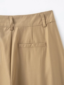 Detail of khaki trousers featuring back pockets and fine twill cotton fabric texture