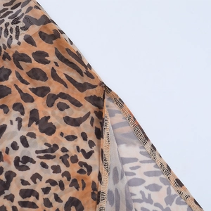 Détail macro du tissu en maille léopard montrant les coutures et la texture de qualité