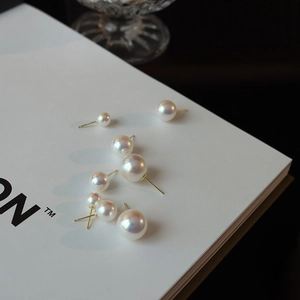 Detailed view of elegant pearl earrings with soft iridescent luster and gold studs