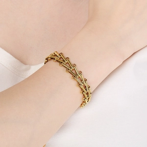 Close-up of 18K gold-plated V-shaped horseshoe link bracelet worn on a model's wrist