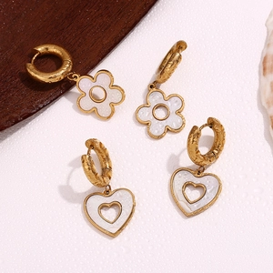 Detailed view of 18K gold plated heart and flower charms on textured hoop earrings