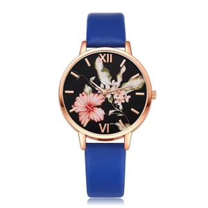 Detailed shot of rose gold flower watch with dark blue leather strap and floral dial