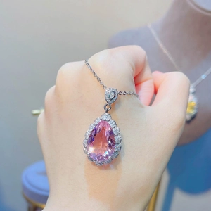 Detail of a 7.5ct pear-cut pink morganite pendant necklace held by a hand