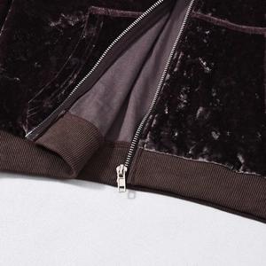 Detailed close-up of dark brown velvet hoodie with metallic zipper and reinforced pockets