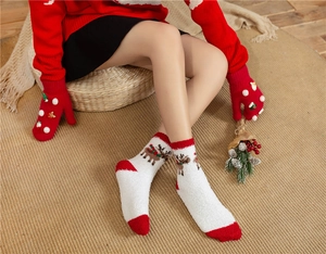 Detail of coral fleece Christmas reindeer socks and red gloves with cute festive charms