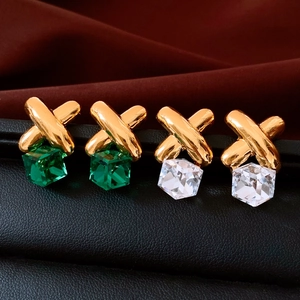 Detail of vintage square crystal cube pendants with golden cross metal ear studs