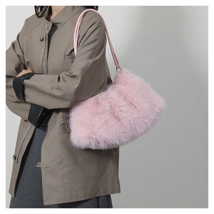 Détail du sac à épaule en fausse fourrure rose avec anneaux dorés sur la bandoulière