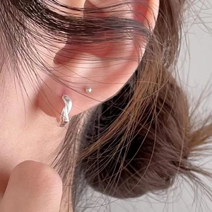 925 silver cross hoop earrings with twisted texture worn on ear for minimalist style