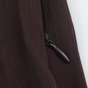 Macro shot of dark brown woven fabric detail with a matching hidden zipper on the dress