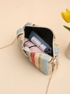 Detail of colorful woven straw camera bag showing interior capacity and golden chain strap