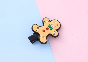 Detailed view of gingerbread man hair clip with a brown silicone finish and metal duckbill clip