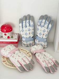 Detailed view of padded ski gloves with teddy bear pattern and non-slip palm patches