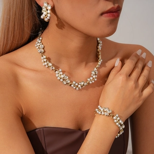 Parure bijoux vintage dorée avec perles et strass sur mannequin pour un look élégant
