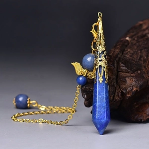 Detail of lapis lazuli hexagonal prism pendant with gold wing charm and beads on a chain
