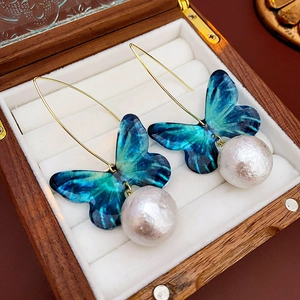 Detailansicht der blauen Schmetterlings-Perlenohrringe in einer Luxus-Schmuckbox