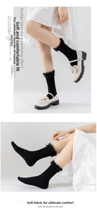 Detail view of black knee-high socks with delicate double-layer lace and mesh trim