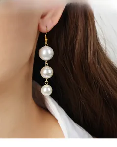 Detail of three-bead gradient faux pearl tassel earrings with gold-finish steel hooks