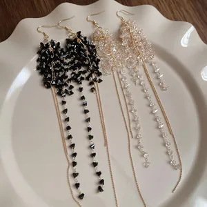 Eleganti orecchini a frange con perline nere e trasparenti e catenine dorate
