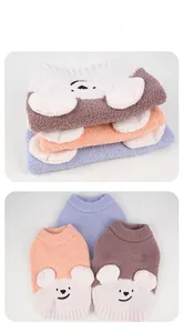 Detailed close-up of soft coral fleece pet sweaters with 3D bear ears on the back
