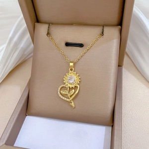 Macro shot of gold sunflower heart necklace with cubic zirconia on brown jewelry box