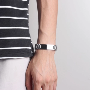 Close-up of a men's 15mm silver watch-band style bracelet on a wrist in natural light