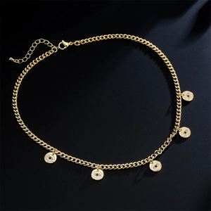 Macro detail of gold Cuban chain necklace with blue evil eye charms on black texture
