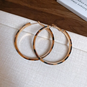 Close-up of leopard print resin hoop earrings with elegant gold-tone metal trimming